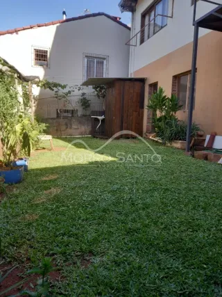 Foto externa mostrando um gramado verde em frente à fachada da casa.