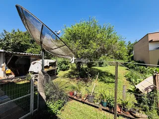 Vista externa de uma propriedade com cerca e jardim.