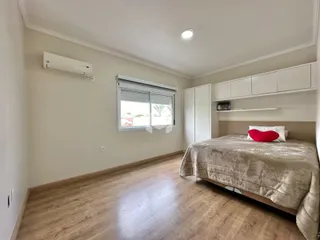 Quarto com piso de madeira e armário embutido.
