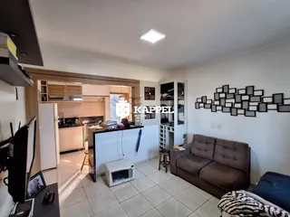 Sala de estar com cozinha aberta em um apartamento.