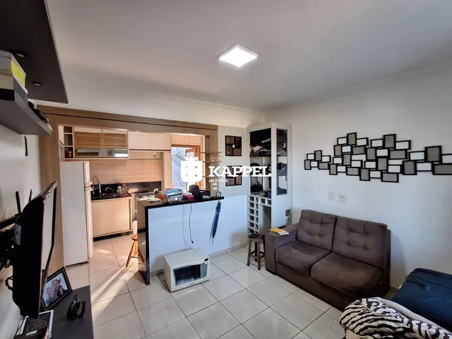 Sala de estar com cozinha aberta em um apartamento.