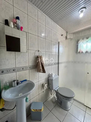 Banheiro com revestimento cerâmico nas paredes e piso.