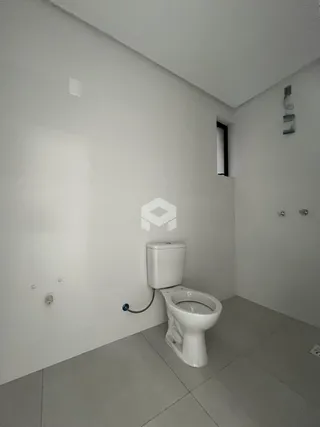 Foto de um banheiro interno com piso de cerâmica e paredes brancas.