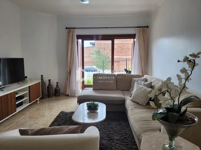 Sala de estar com sofá e porta de vidro que dá para o exterior.