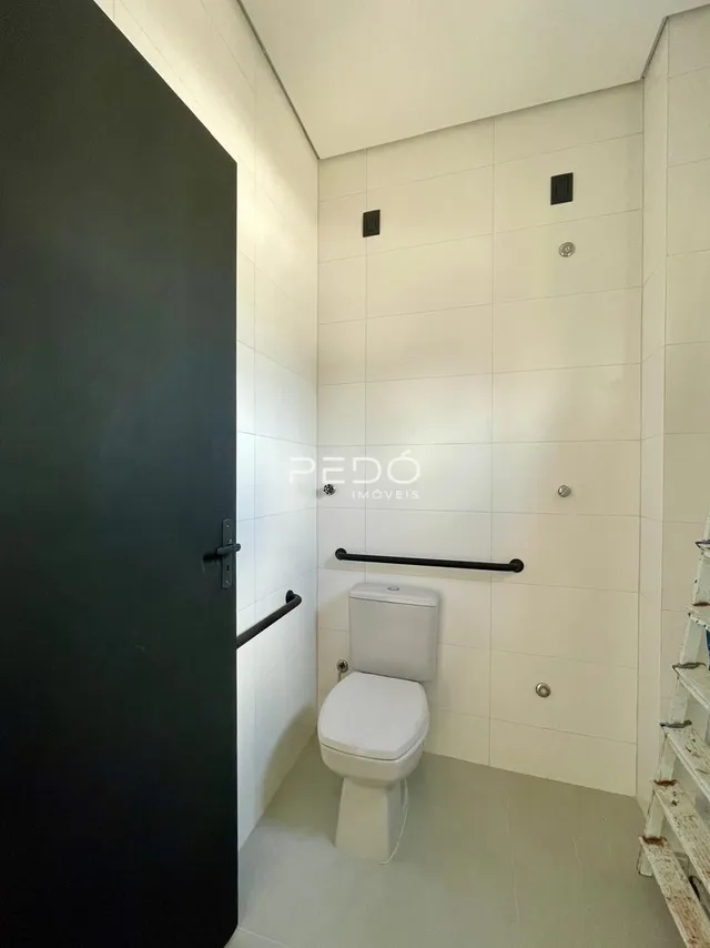 Foto interna de um banheiro com revestimento cerâmico nas paredes.