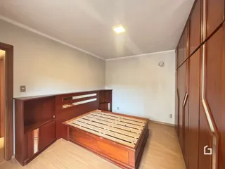 A foto mostra o interior de um quarto com móveis de madeira.