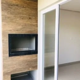 Detalhe de uma parede com acabamento em textura clara e nicho escuro em um imóvel.
