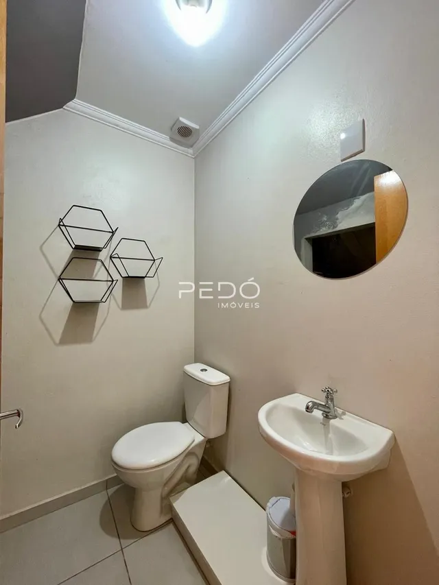 Foto de um banheiro interno com vaso sanitário e pia brancos.