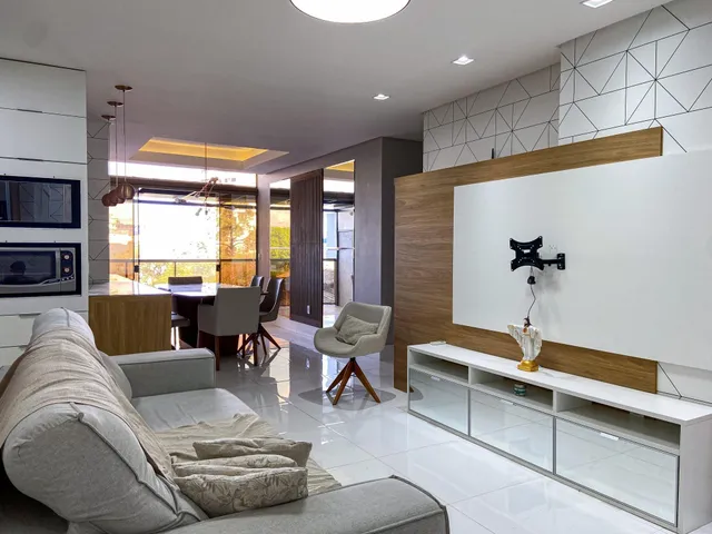 Sala de estar moderna com sofá grande e vista para o exterior.