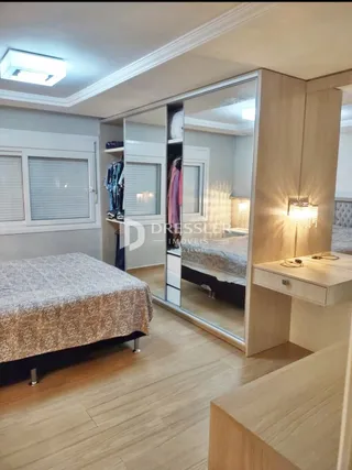 Quarto com cama e armário refletido em espelho.