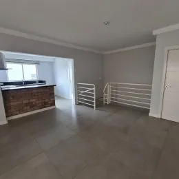 Foto de uma sala ampla com piso de cerâmica e área de serviço visível.