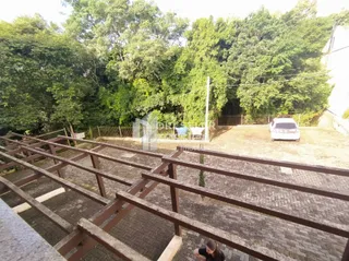 Vista externa da propriedade com vegetação densa ao fundo.