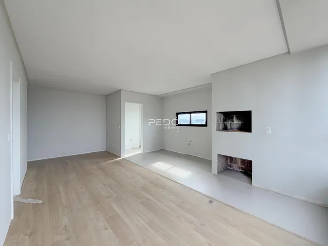 Ambiente interno com piso de madeira clara e paredes brancas.