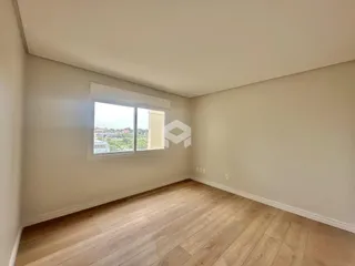 Sala de estar com piso de madeira clara e grande janela.