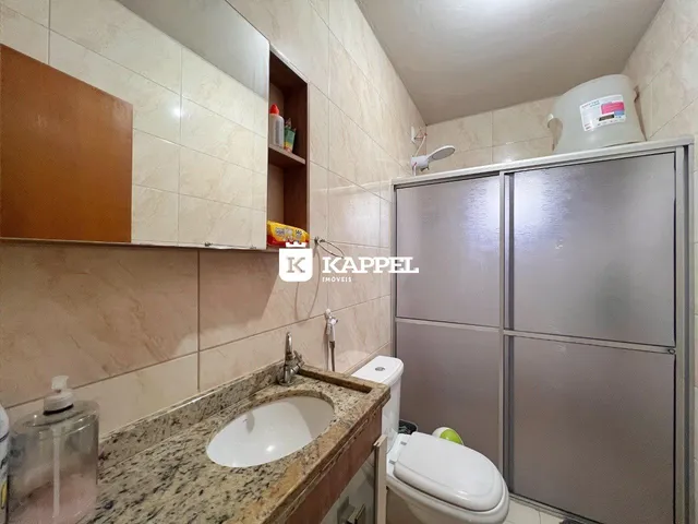 Foto de um banheiro com bancada de granito e louças sanitárias.