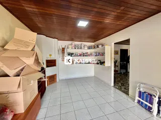 Ambiente interno com caixas de mudança e prateleiras brancas em um cômodo.