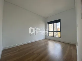 Foto de uma sala com piso de madeira clara e paredes brancas.