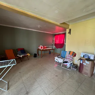 Ambiente interno de uma sala com piso de cerâmica e paredes em tons de verde e amarelo.