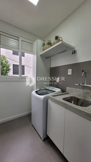 Uma cozinha moderna com armários brancos e bancada de granito.