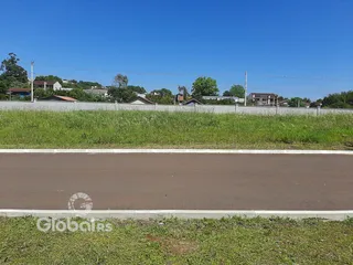 Vista da propriedade com gramado e cerca ao longo da rua.