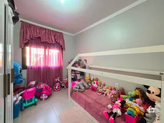 Quarto com cama e cortinas rosa na sala.