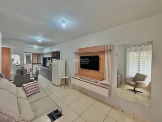 Sala de estar com sofá e televisão em um apartamento.