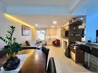 Sala de estar com sofá e mesa de jantar em um apartamento.