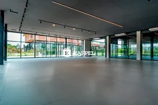 Uma vista ampla de um espaço interno moderno com grandes janelas de vidro.