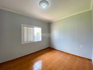 Ambiente interno de uma sala com piso de cerâmica e janela.