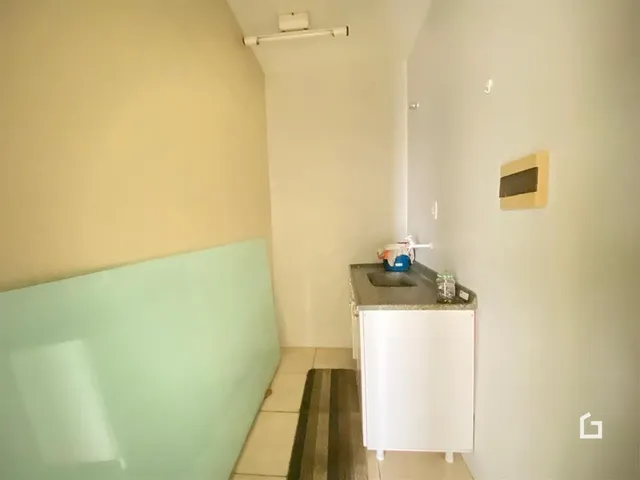 Vista de um corredor interno com paredes claras e piso de cerâmica.