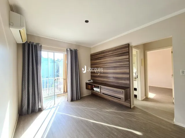 Sala de estar com painel de madeira e porta de vidro.
