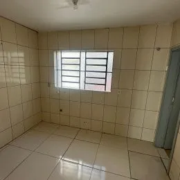 Foto de um cômodo interno com paredes claras e janela com persianas.