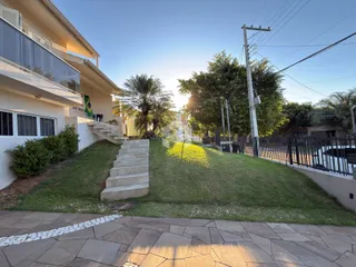 Fachada de uma residência com jardim e escadaria em Lajeado, Brasil.