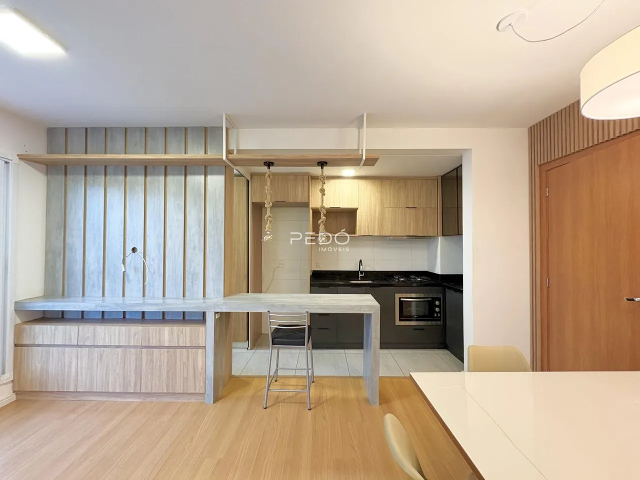 Ambiente de sala de estar e cozinha em um imóvel no Brasil.
