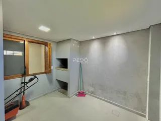 Foto de uma sala com parede de concreto aparente e janela de madeira em um imóvel.