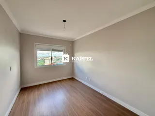 Sala de estar com piso de madeira e janela com vista para a cidade.