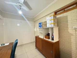 Vista de um ambiente interno com piso de cerâmica e parede de tijolos.