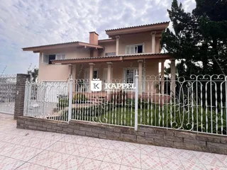 Fachada de uma residência em Lajeado, Brasil, com cerca branca e jardim.
