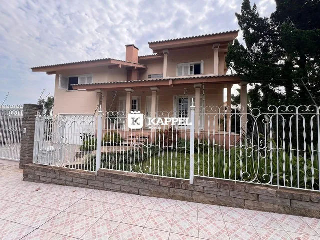 Fachada de uma residência em Lajeado, Brasil, com cerca branca e jardim.