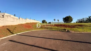 Vista externa da propriedade com muro e terreno inclinado.