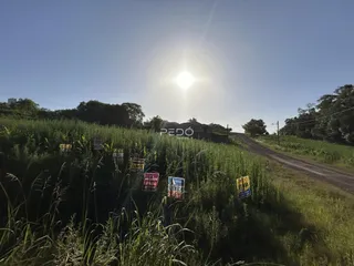 Vista da propriedade em Lajeado, Brasil, com campo gramado e sinais de venda.