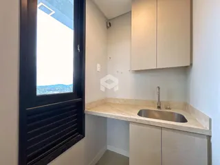 Interior de uma cozinha com bancada e armários brancos.