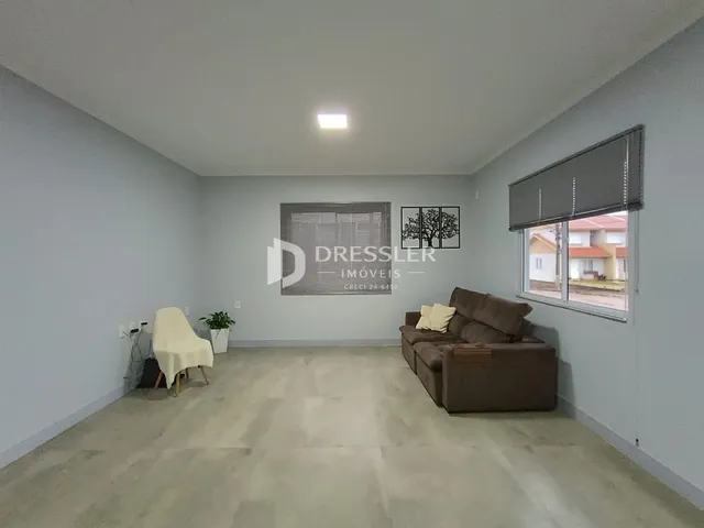 Sala de estar com sofá e janela em um imóvel no Brasil.