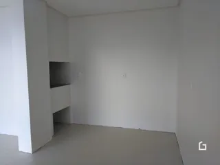 Interior de um espaço com paredes brancas e piso cinza claro.