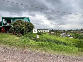Fachada de uma residência em Lajeado, Brasil, com gramado e vegetação em primeiro plano.