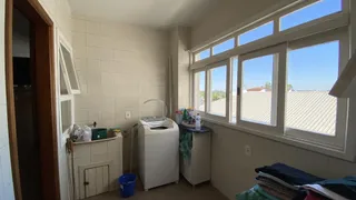 Uma área interna com grandes janelas que oferecem uma vista externa e uma máquina de lavar roupa.
