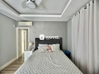 Quarto com cama grande e decoração neutra.