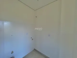 Hall de entrada com paredes brancas e piso claro.