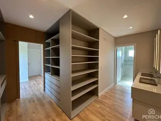 Ambiente interno com estantes grandes e piso de madeira clara.