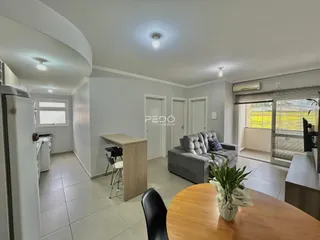 Sala de estar com sofá e mesa de jantar em um imóvel no Brasil.